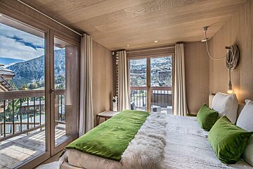 A bedroom with a bed and a view of the mountains