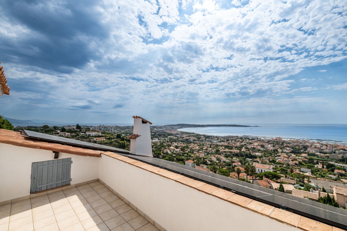 A balcony with a view of a city and the ocean
