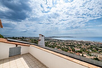 A balcony with a view of a city and the ocean