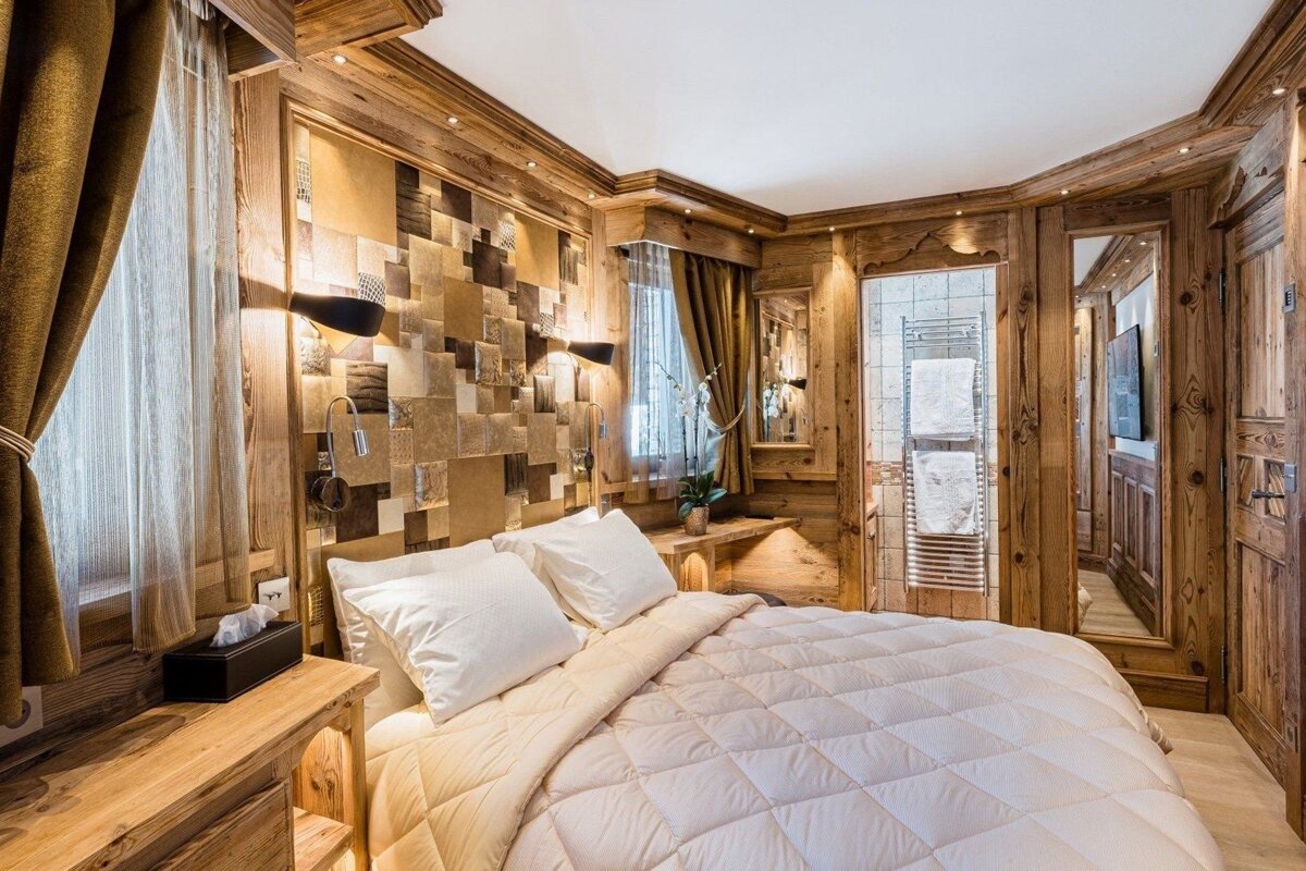 A bedroom with a large bed and a mirror