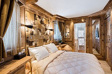 A bedroom with a large bed and a mirror