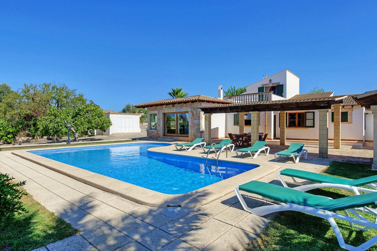 A house with a large swimming pool in front of it