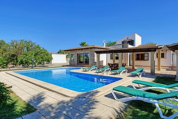 A house with a large swimming pool in front of it