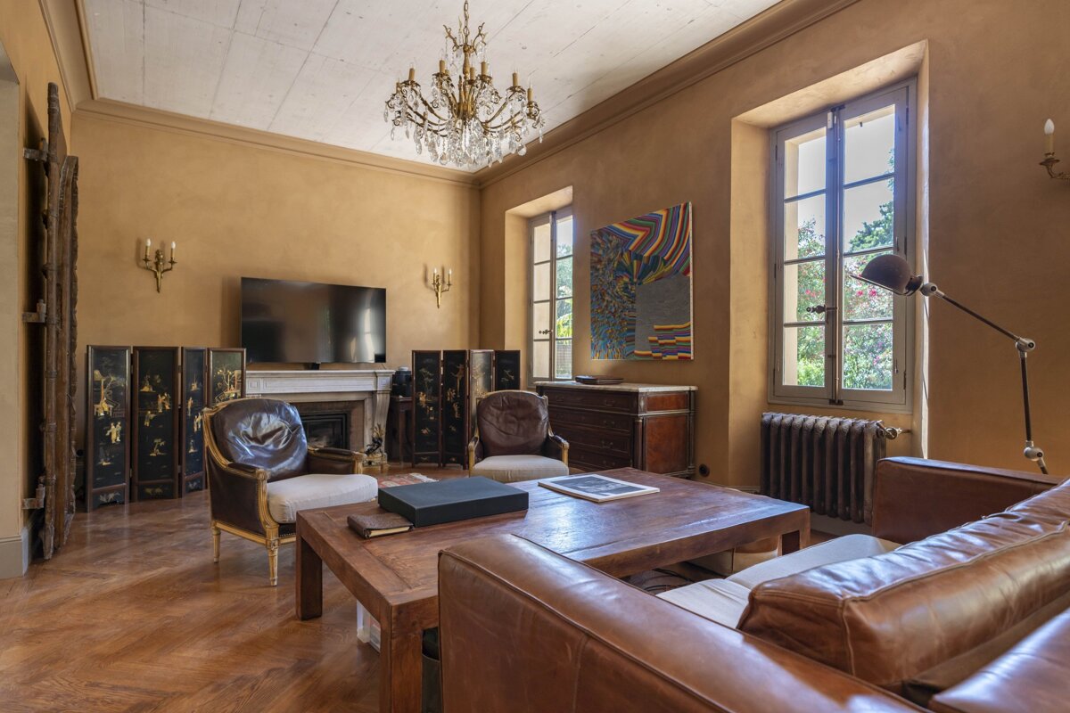 A living room with a couch and chairs and a television