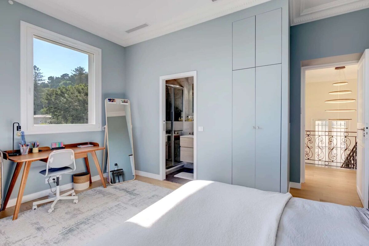 A bedroom with a desk and a mirror with a sticker that says ' i love you ' on it