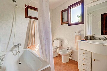 A bathroom with a bathtub a toilet and a bidet