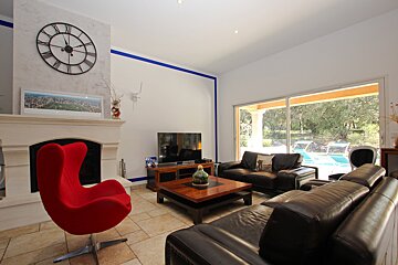 A living room with a large clock above the fireplace