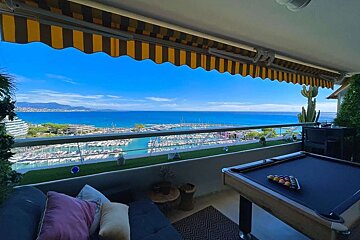 A pool table on a balcony overlooking the ocean