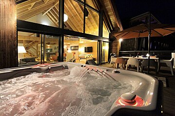A hot tub in front of a house at night