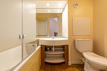 A bathroom with a toilet a sink and a mirror