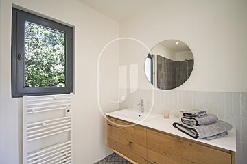 A bathroom with a sink and a round mirror