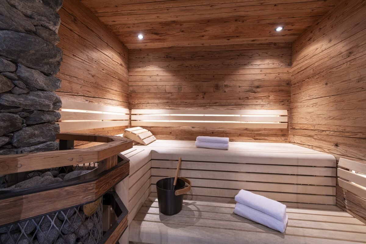 A wooden sauna with white towels and a black bucket