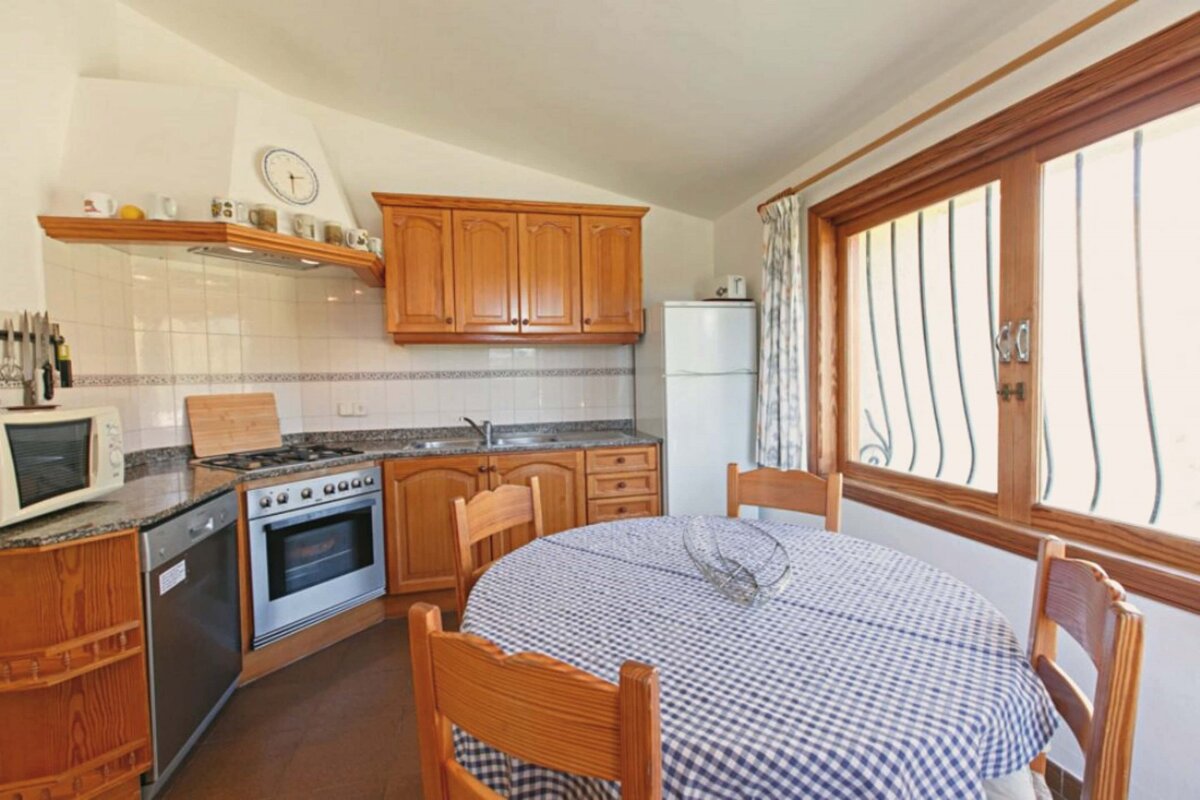 A kitchen with a table and chairs and a clock on the wall
