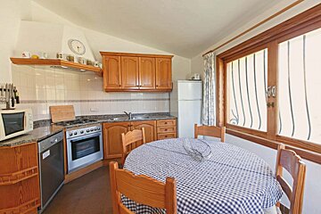 A kitchen with a table and chairs and a clock on the wall
