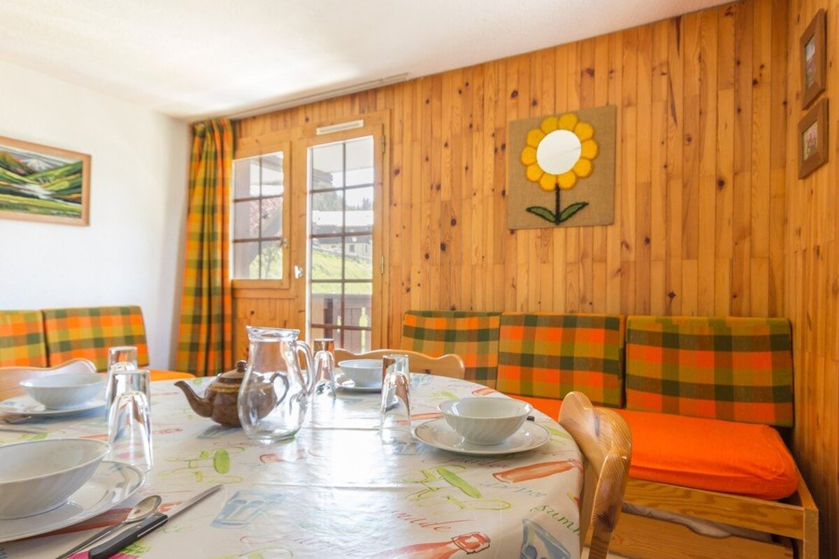 A room with a table and chairs and a flower on the wall