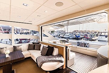 A living room with a couch and a table looking out to a marina