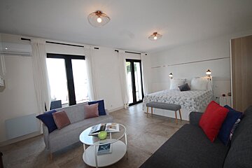 A living room with a couch a coffee table and a bed