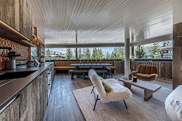 A living room with a table and chairs and a view of the mountains
