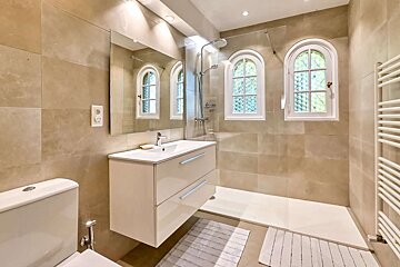 A bathroom with a walk in shower and stained glass windows