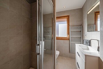 A bathroom with a toilet a sink and a towel rack