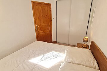 A bedroom with a wooden door and a bed