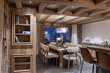 A dining room with a large table and chairs
