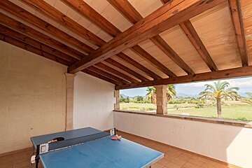 A ping pong table in a room with a wooden ceiling