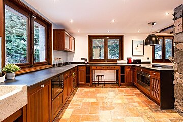 A kitchen with wooden cabinets and black counter tops