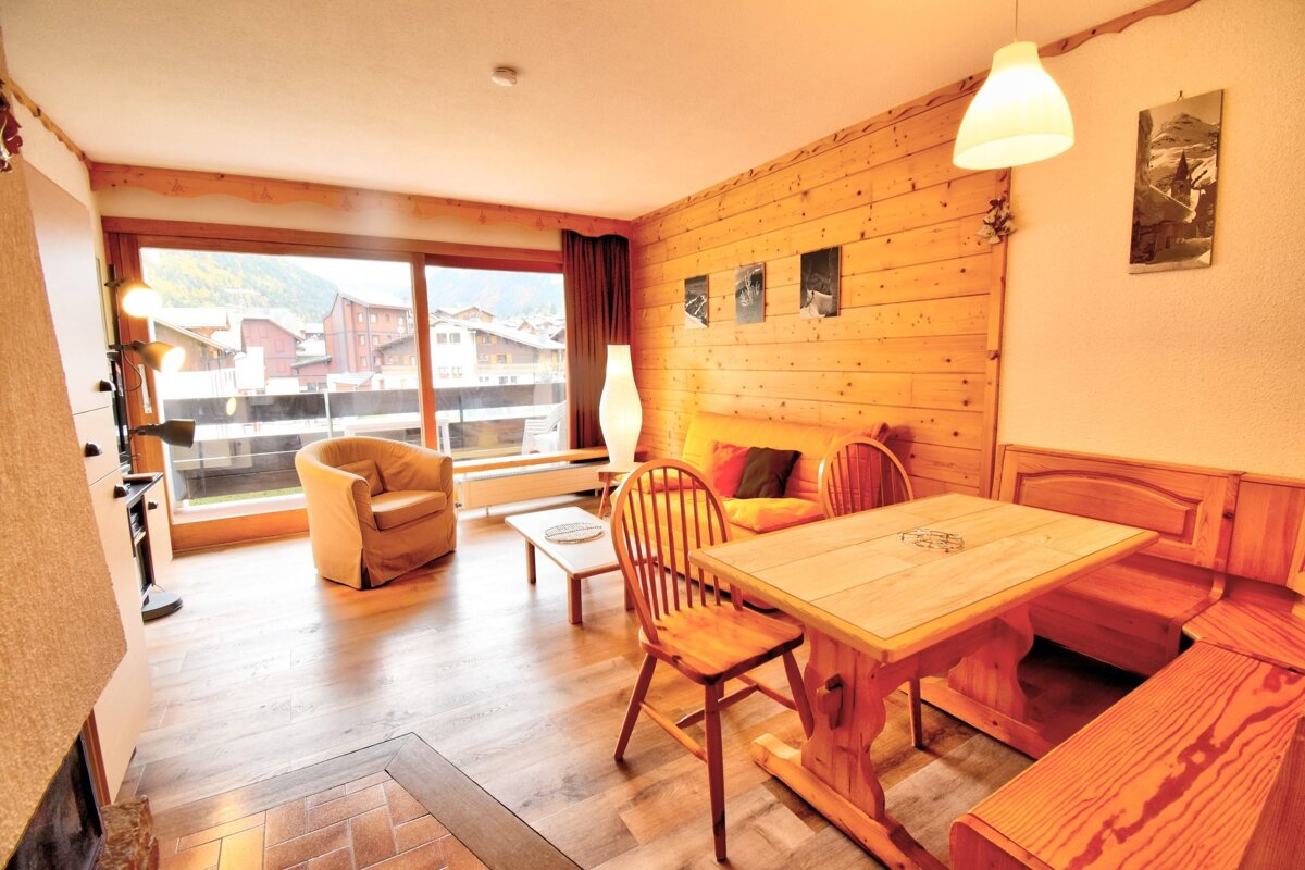 A living room with a wooden table and chairs