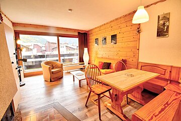 A living room with a wooden table and chairs