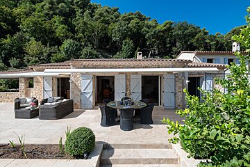 A patio with a table and chairs in front of a house