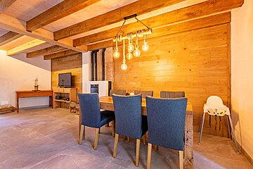 A dining room with a wooden table and chairs