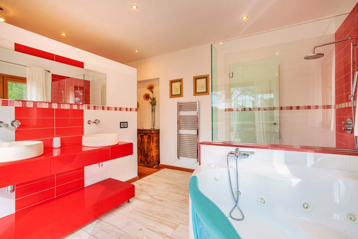 A bathroom with red tiles and a jacuzzi tub