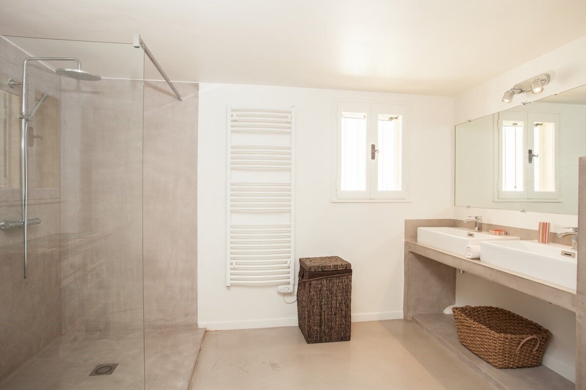 A bathroom with a walk in shower and two sinks