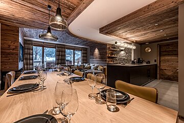 A dining room table with plates and glasses on it