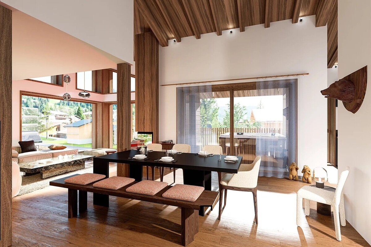 Spacious, modern chalet interior with an open-plan living and dining area, featuring warm wood accents, large windows, and subtle bear-themed decor.