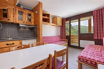 A kitchen with a table and chairs and a couch