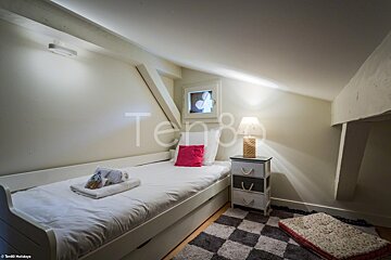 A bedroom with a single bed and a lamp and the word ten on the wall