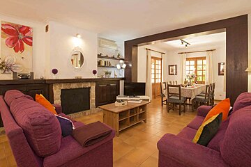 A living room with purple furniture and a fireplace
