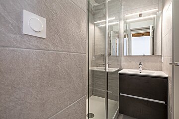 A bathroom with a sink and a walk in shower