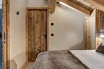 A bedroom with a bed and a wooden door