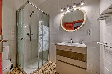 A bathroom with a toilet a sink and a shower