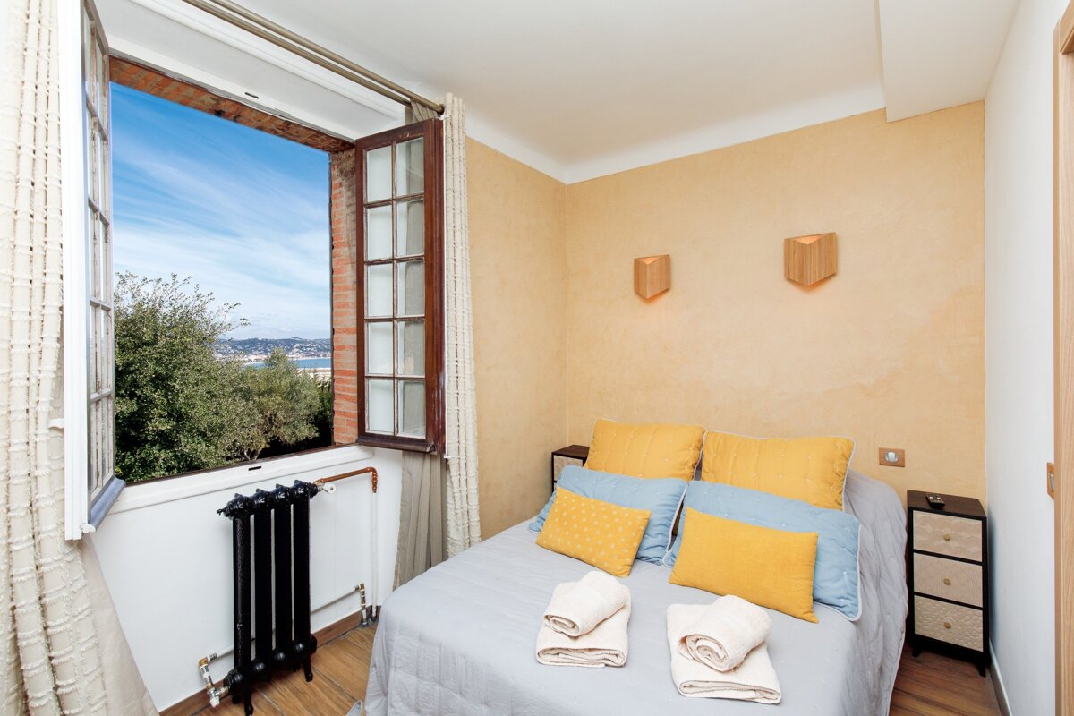 A bedroom with a bed and a window with a view