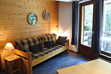 A living room with a couch and two mirrors on the wall