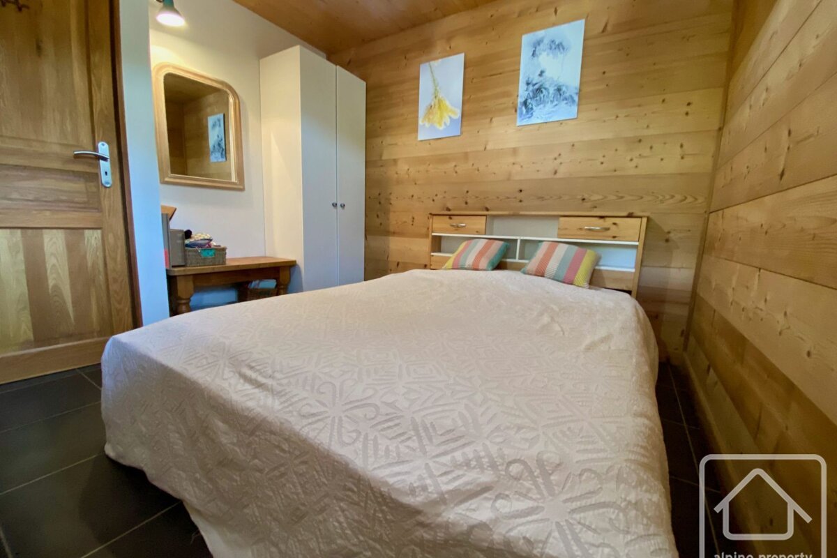 A bedroom with a bed and two paintings on the wall