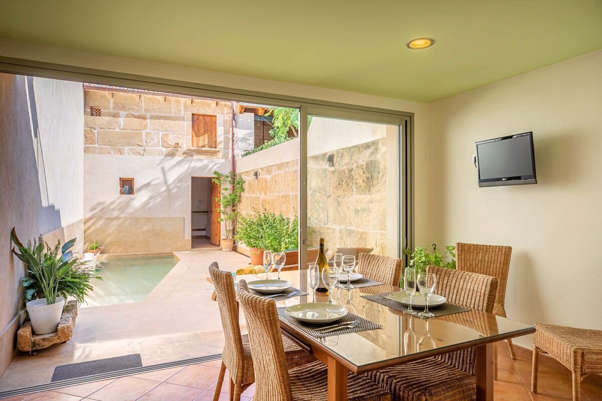 A dining room with a sliding glass door leading to a pool