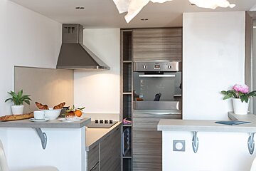 A kitchen with a stove top oven and a hood
