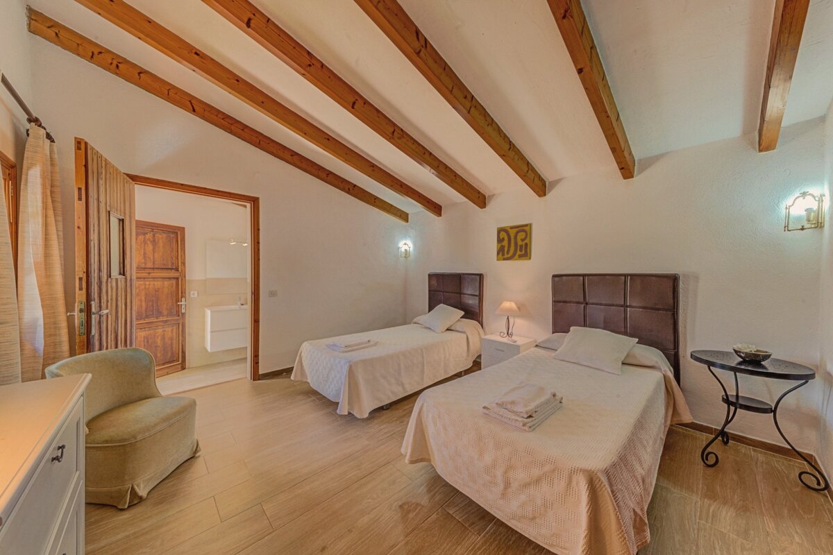 A bedroom with two twin beds and a chair