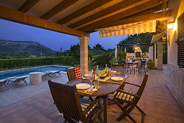A patio with a table and chairs and a striped awning