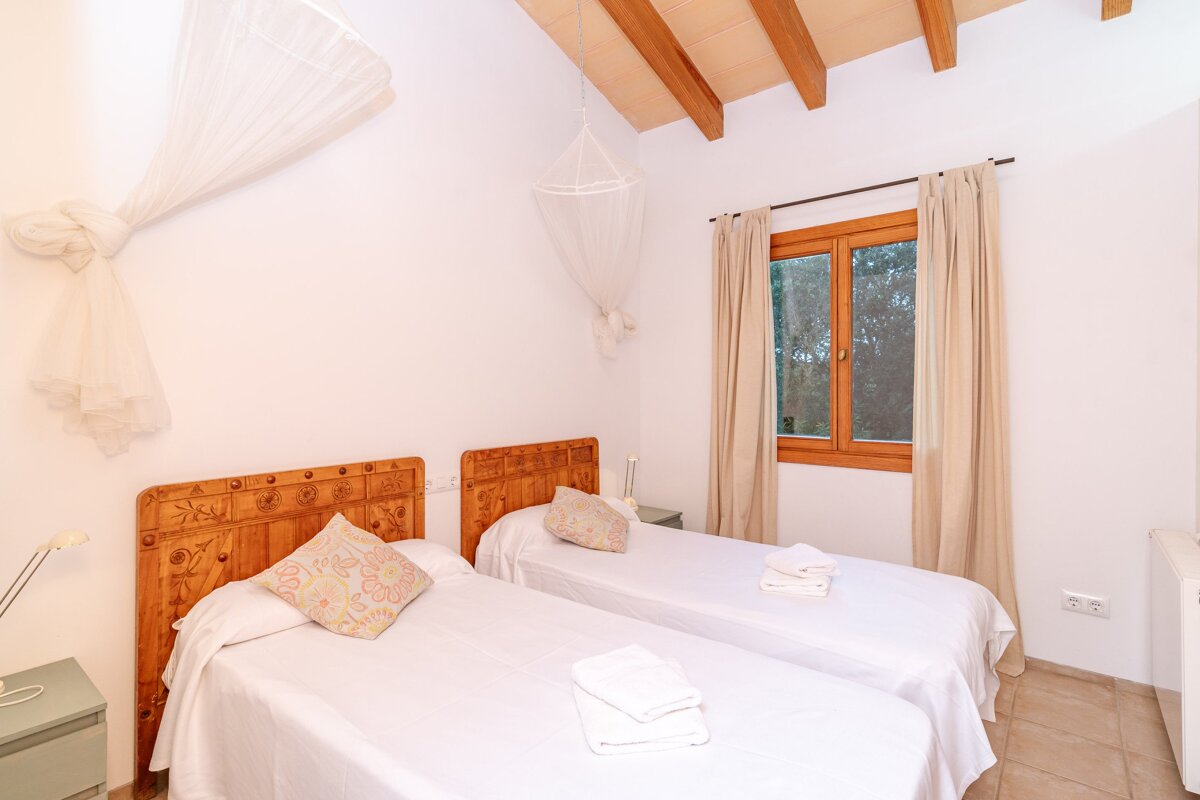 A bedroom with two twin beds and a window